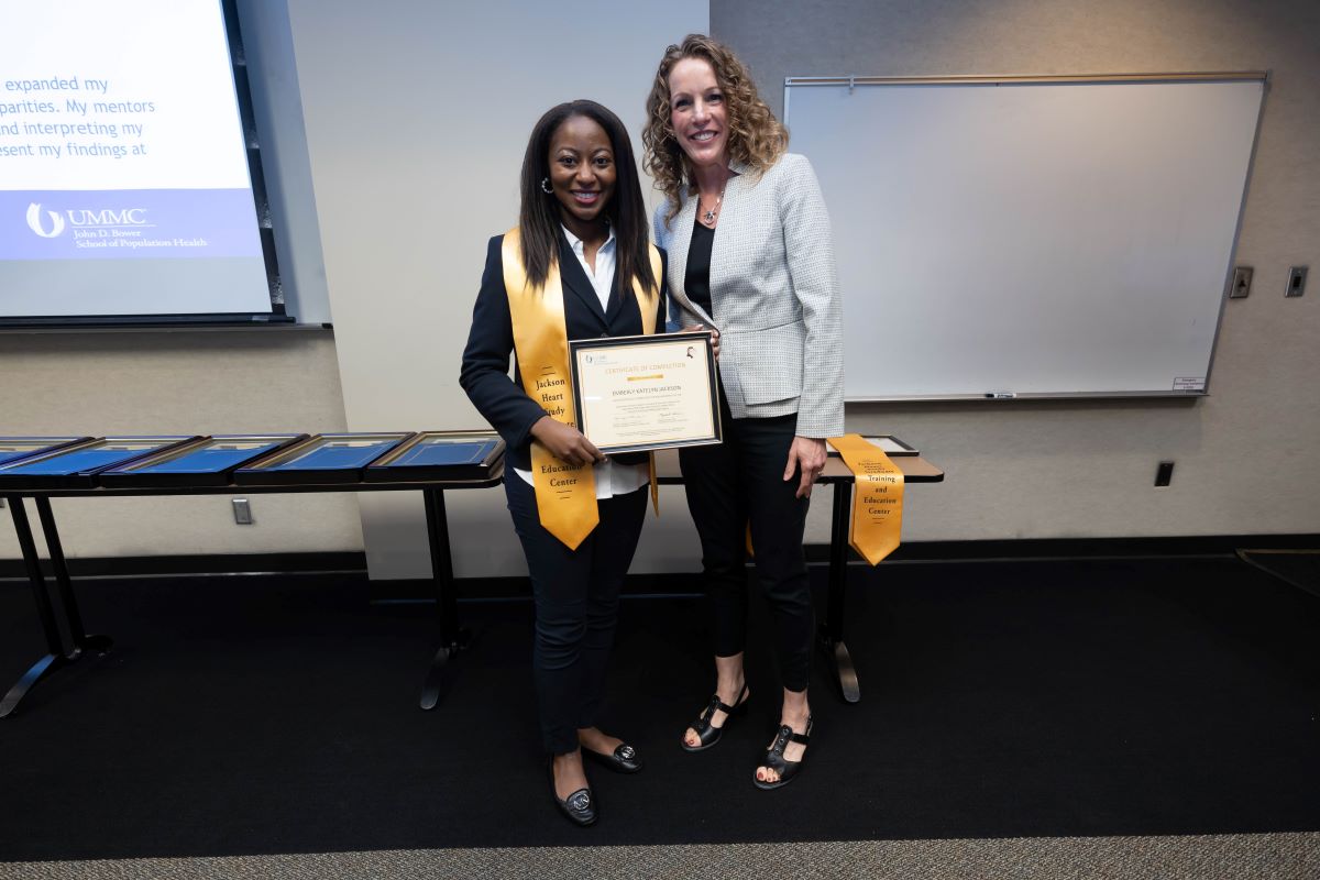 Student standing with Dr. Reneker with stole and certificate at the 2023 SOPH Research Day